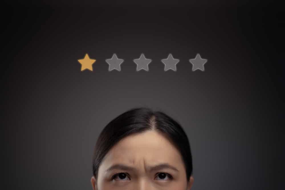Close up shot of unhappy Asian woman and star icon hologram effect.